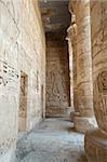 Egyptian hieroglyphic carvings on a wall at the temple of Medinat Habu in Luxor with columns