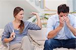 Man being tired of arguing with his wife in their living room