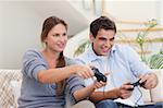Couple playing video games in their living room