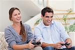 Smiling couple playing video games in their living room