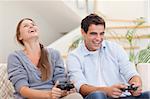 Happy couple playing video games in their living room
