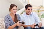 Young couple playing video games in their living room