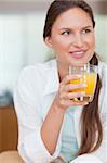 Portrait of a happy woman drinking juice in her kitchen