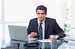 Businessman working with a laptop and a graph in his office