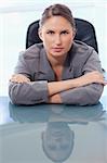 Portrait of a serious businesswoman leaning on her desk while looking at the camera