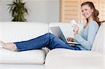Young woman sofa placing an order online