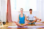 Young man and fit woman doing yoga at home