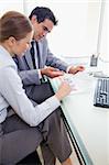 Side view of young colleagues doing paper work together