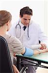 Young doctor checking his patients blood pressure