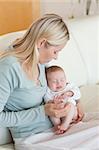 Young mother on the sofa with her baby on her lap