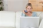 Young woman using credit card to book flight