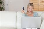 Young woman on the sofa booking holidays online