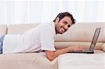 Smiling man using a notebook in his living room