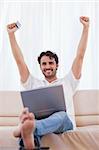 Portrait of a cheerful man buying online in his living room