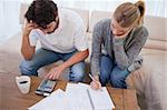 Couple looking at their bills in their living room