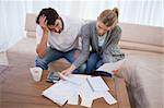 Depressed couple doing their accounting in their living room