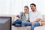 Couple watching TV in their living room