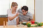 Charming couple preparing a sauce in their kitchen