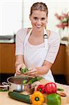 Portrait of a smiling woman cooking in her kitchen