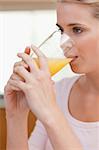 Portrait of a quiet woman drinking juice in her kitchen