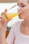 Portrait of a calm woman drinking orange juice in her kitchen