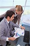 Portrait of a manager and his secretary looking at a graph in his office