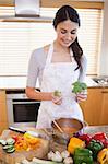 Portrait of a woman cooking a soup in her kitchen