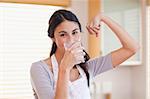 Healthy woman drinking milk in her kitchen