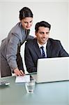 Portrait of sales persons working with a laptop in an office