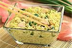 Asian noodle soup with chicken and green onions in glass bowl (Selective Focus, Focus on the meat between the chopsticks)