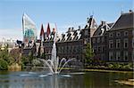 The exterior of the Binnenhof, or Netherlands Parliament building in The Hague, as viewed over the Hofvijver lake and fountain.