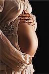 Pregnant woman belly over black