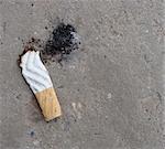 cigarette butt with ash showing shoe print