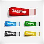 A set of colorful paper tags attached with sticky tape.