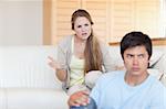Upset young couple arguing in their living room
