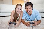 Smiling couple playing video games in their living room