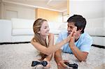 Playful young couple playing video games in their living room