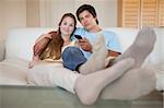 Relaxed couple watching television in their living room