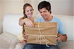 Couple opening a package in their living room