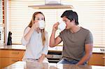 Young couple having a cup of tea in their kitchen