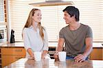 Young couple having a cup of coffee in their kitchen