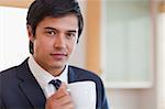 Close up of a handsome businessman drinking coffee in his kitchen