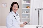 Smiling doctor using a tablet computer in a hospital