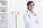 Smiling young doctor standing in examination room