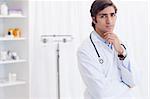 Male young doctor standing in examination room