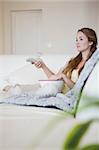 Young woman on the sofa enjoying a movie with popcorn
