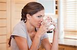 Side view of young woman enjoying coffee