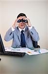 Young businessman looking through binoculars
