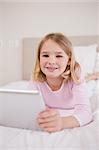 Portrait of a girl using a tablet computer in her bedroom