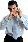 A very worried or anxious businessman or other professional on the phone.  White background.